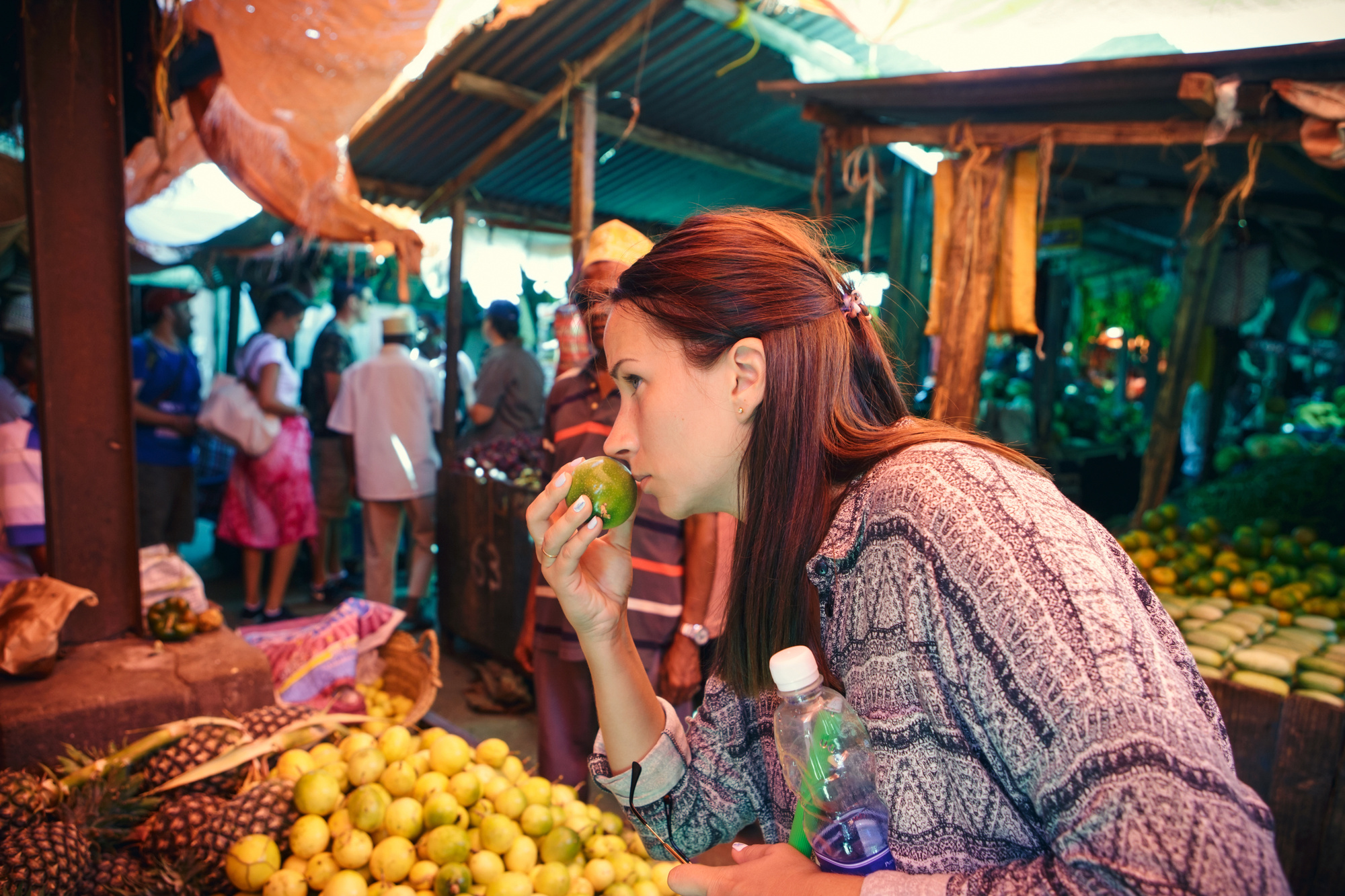Young woman chooses fruits at the local African market