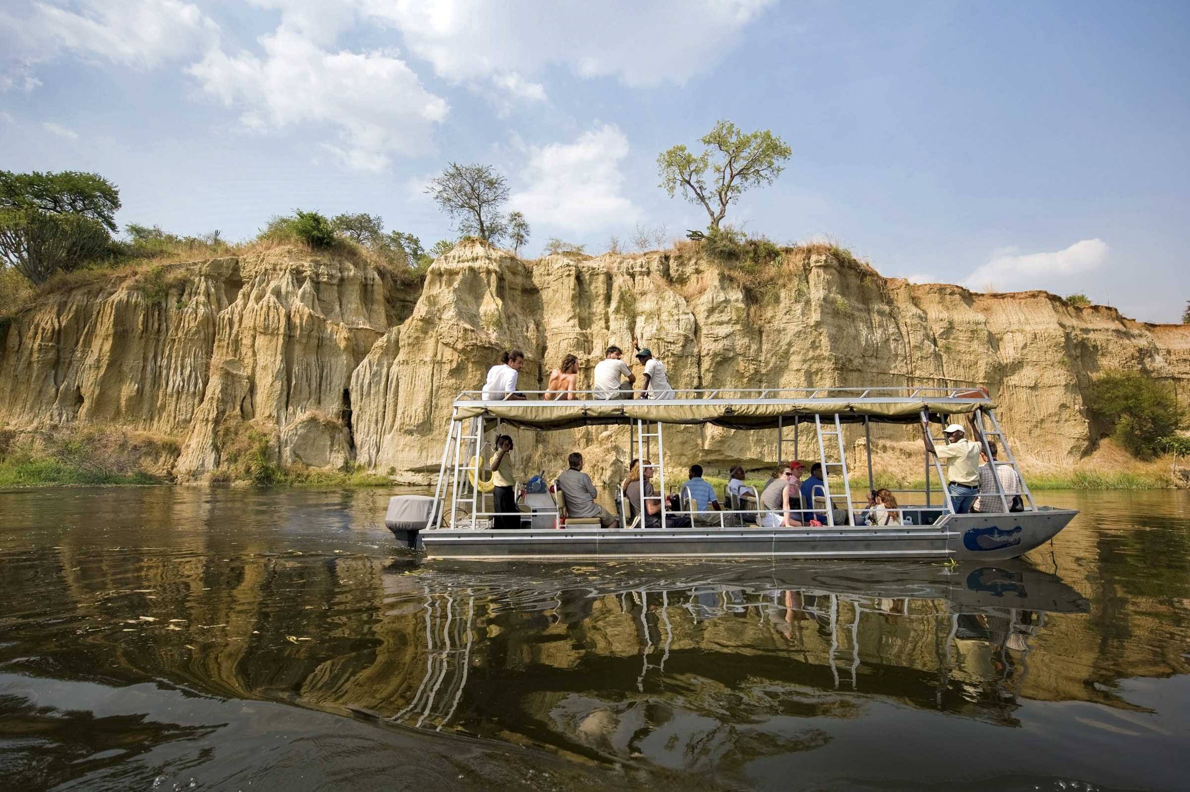 Guests on the launch on the Victoria Nile below the cliffs at Murchison Falls, Uganda